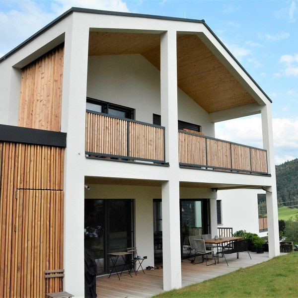 Die zweite Haushälfte, senkrechte Holzschalung am Giebel, davor der durchlaufende Balkon