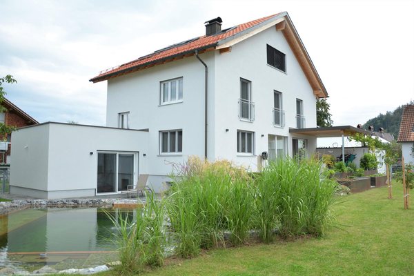 Die Gartenseite nach der Sanierung, links der flach gedeckte Anbau, davor der Naturteich