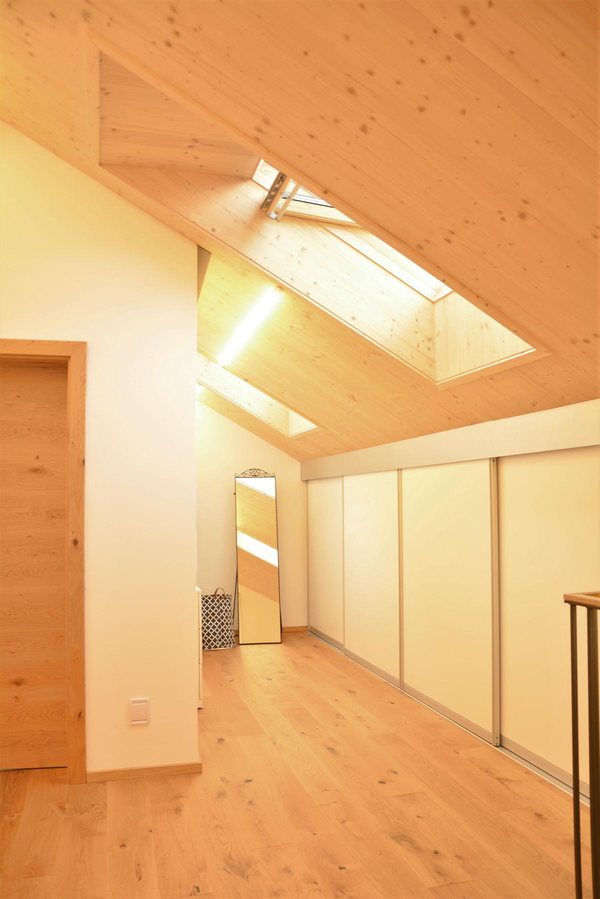 Das neue Vollgeschoß unter der sichtbaren Holzdecke, zwei große Dachfenster über dem Gang