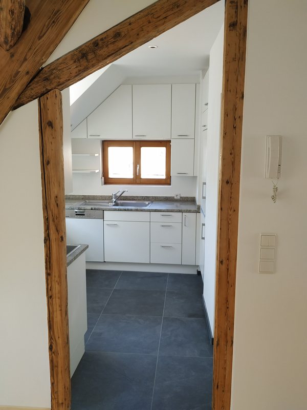 Blick durch das alte Gebälk in die neue Küche