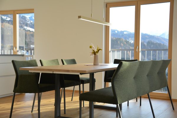 Der Essplatz vor den Fenstertüren zur Terrasse, dahinter der Blick über das Tal