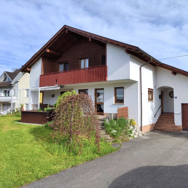 Straßenseite vor der Sanierung, April 2024, verputzte Fassade, Balkon und Garage auf Straßenniveau