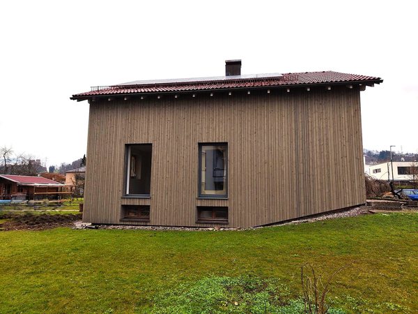 Die Westseite nach der Sanierung, Holzschirm über der gedämmten Fassade
