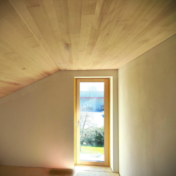 Zimmer im ausgebauten Obergeschoß unter der neuen Holzdecke, Fenstertür zum Balkon