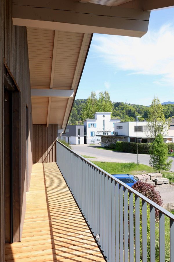 Der erhaltene und sanierte Balkon im Obergeschoß, Holzbelag und Stabgeländer unter dem vorstehenden Dach