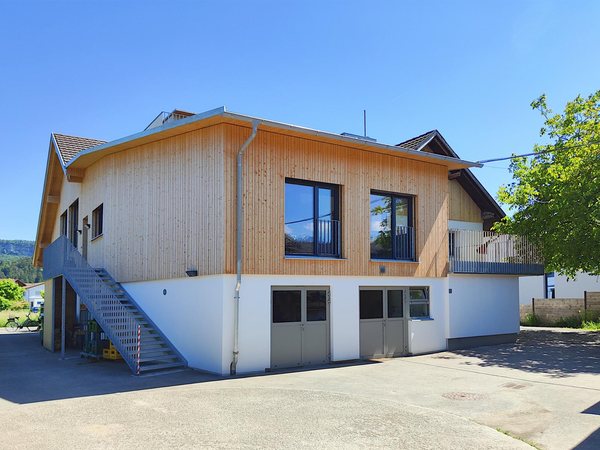 Der Holzbau über dem Geschäft nach dem Umbau, mit der neuen Außentreppe zu den Wohnungen