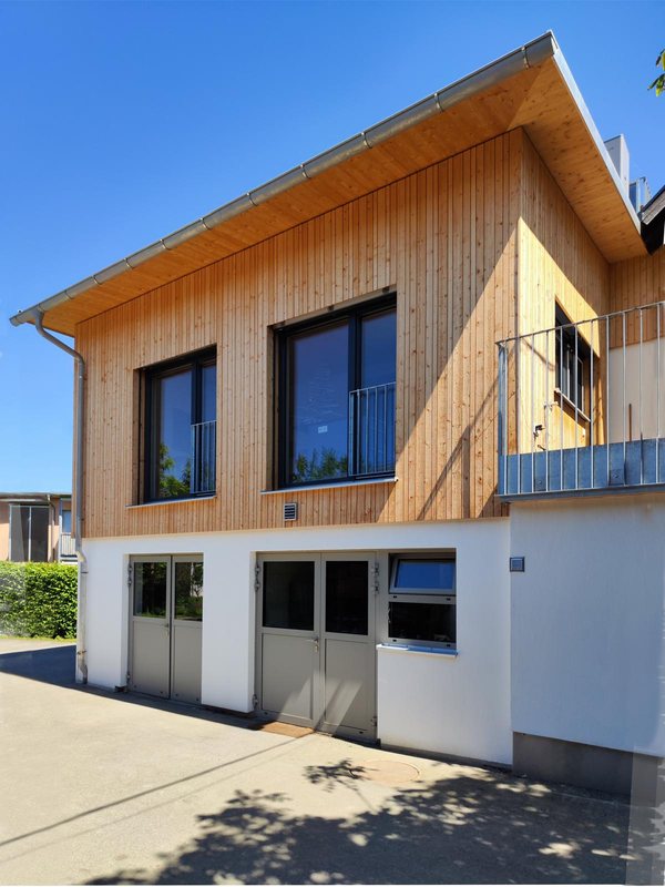 Die Holzfassade des Aufbaus mit Balkon, von der Hofseite
